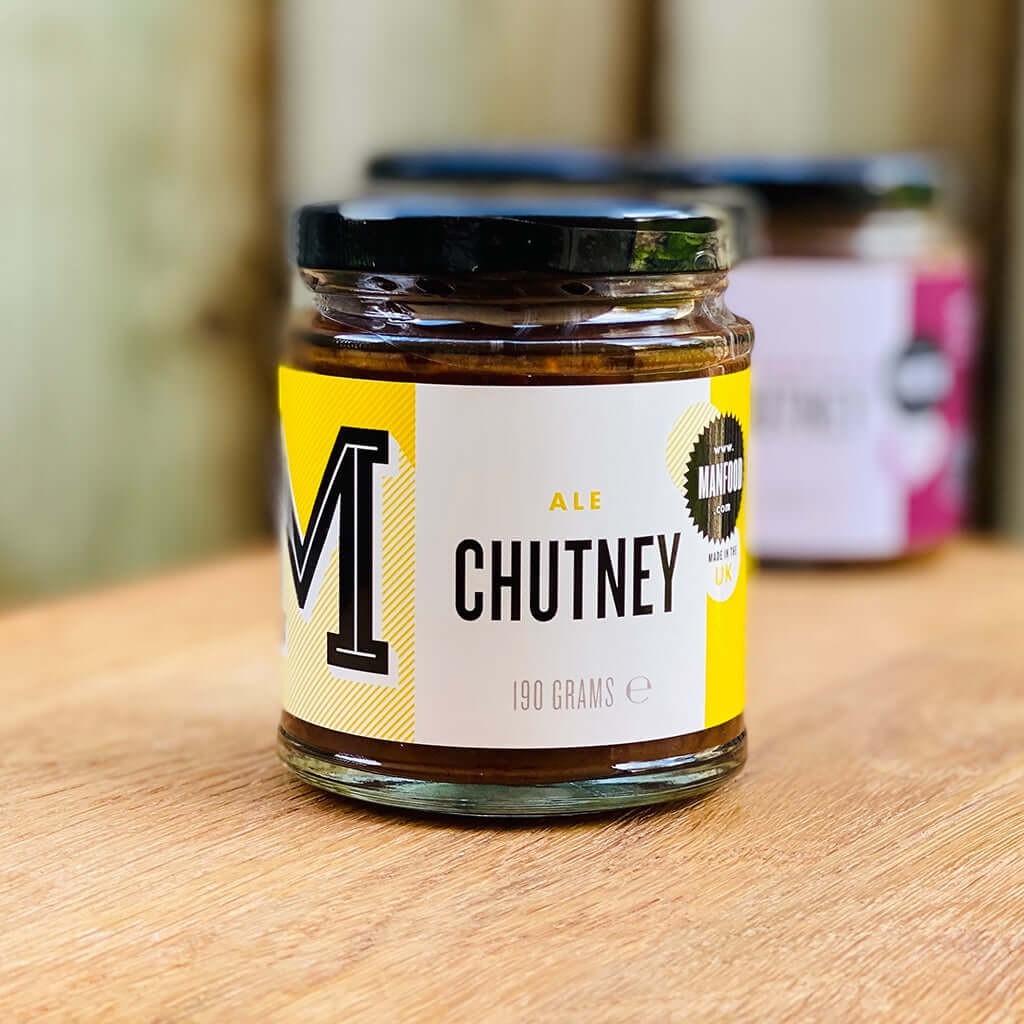 Manfood Ale Chutney in a glass jar with a yellow label, featuring a chunky dark plum and ale fruit preserve.