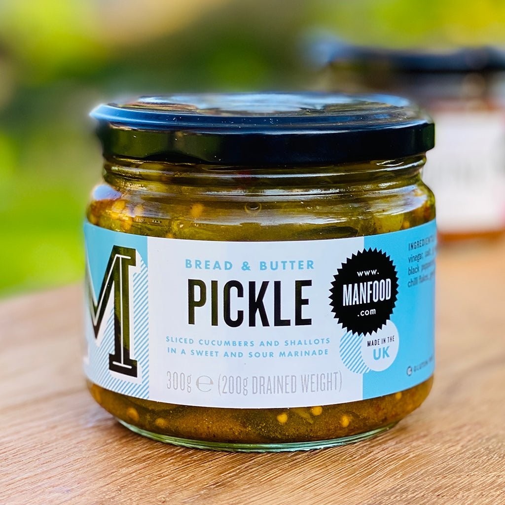 Manfood Bread and Butter Pickle in a glass jar with a black lid, featuring sliced cucumbers and shallots.