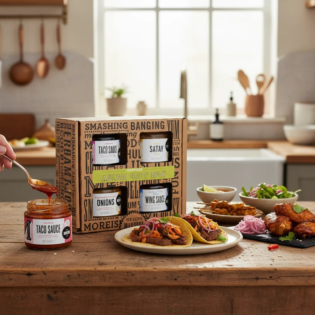 Manfood Cambs Asian Gift Box featuring four gourmet sauces and pickles displayed on a rustic kitchen table.