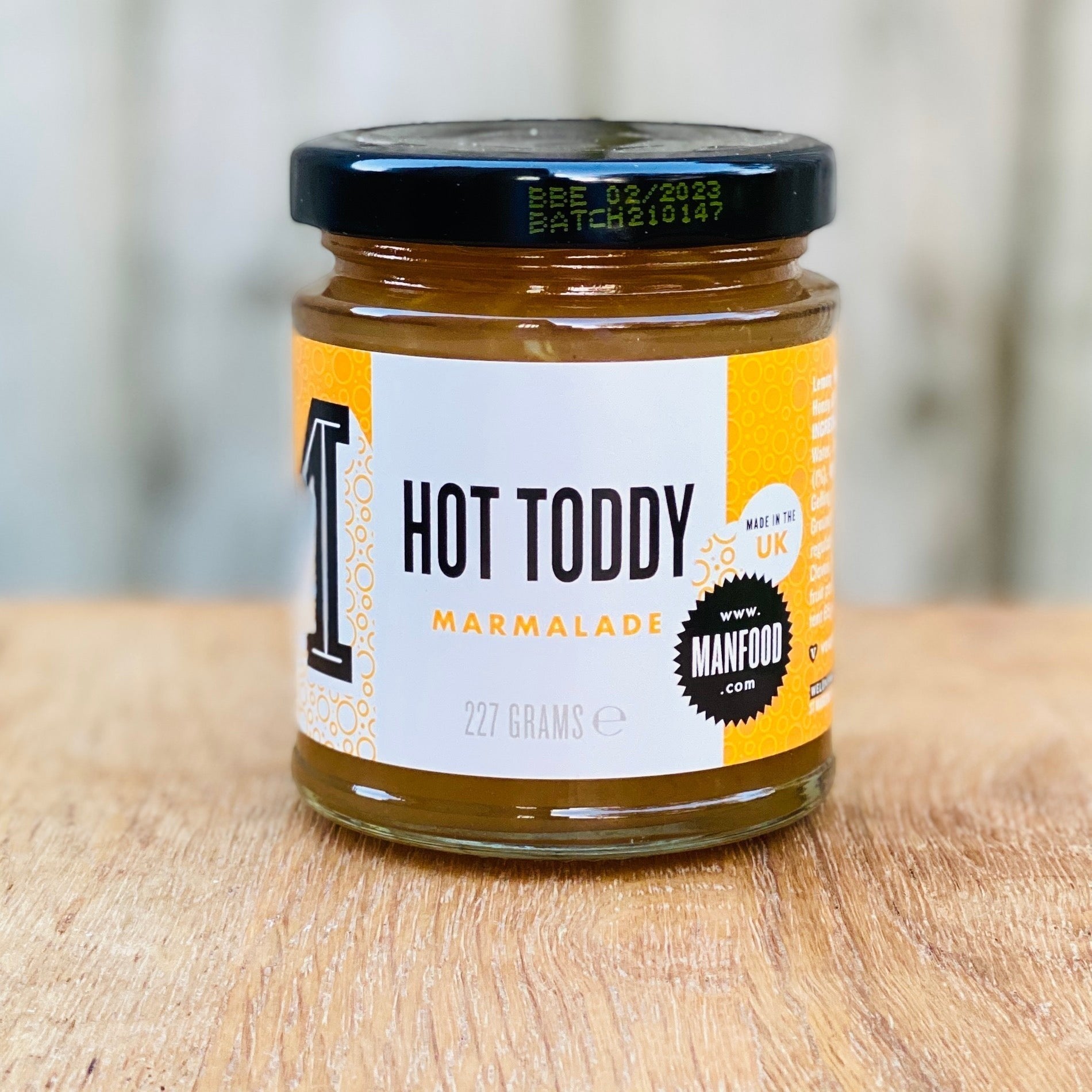 Manfood Cambs Hot Toddy marmalade jar with lemon, whisky, honey, and ginger, 227g glass jar on a wooden surface