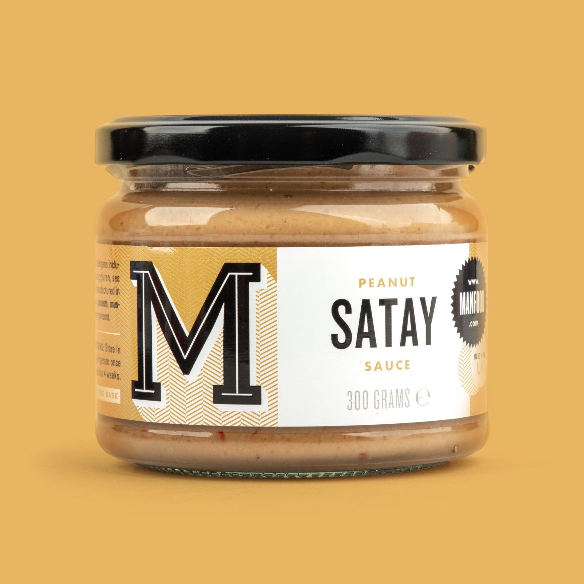 Manfood Peanut Satay Sauce in a 300g glass jar with a black lid against a solid yellow background.