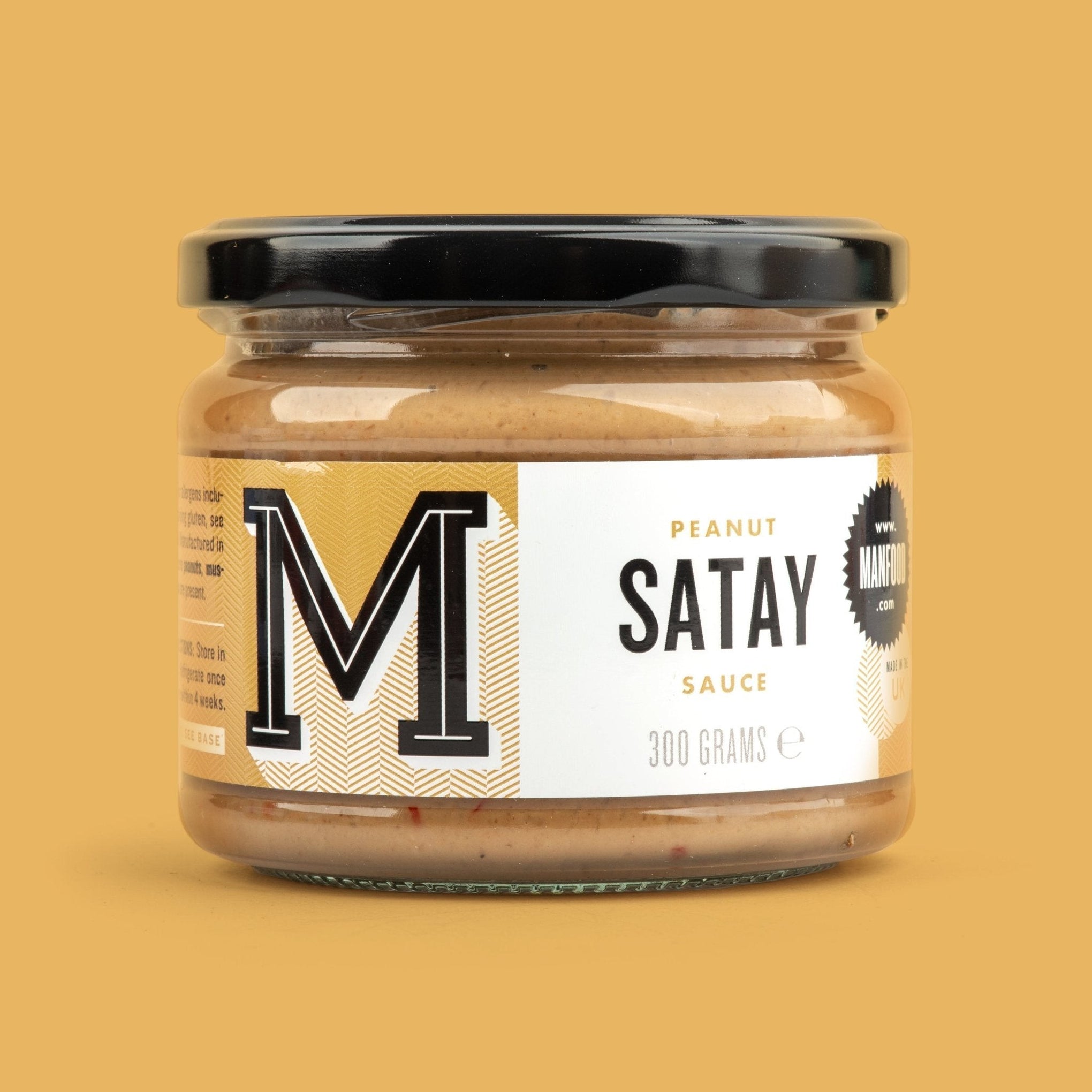 Manfood Peanut Satay Sauce in a 300g glass jar with a black lid against a solid yellow background.