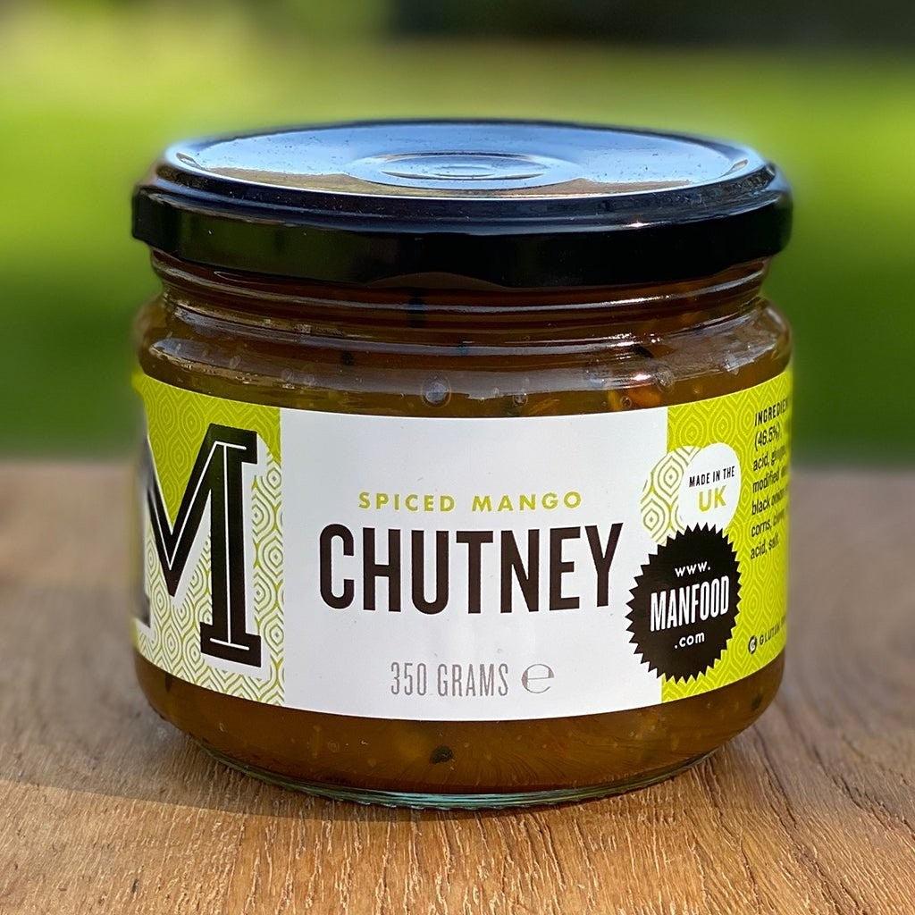Manfood Spiced Mango Chutney in a glass jar with a black lid, featuring a green and white label.